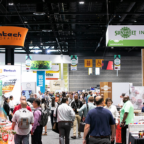 Busy IFT FIRST show floor with attendees walking through the exhibitor booths